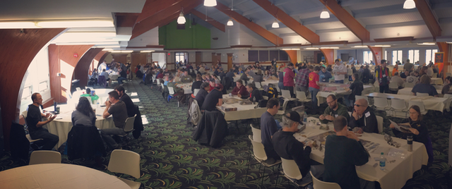 A panoramic view of a ski lodge ballroom full of people playing tabletop games.